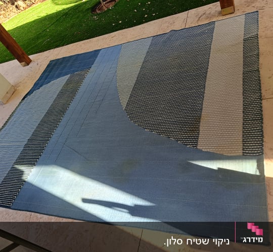 שטיח כחול עם דוגמאות על רצפת אבן